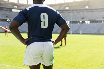 Wall Mural - Male rugby player standing with hands on hip in the stadium