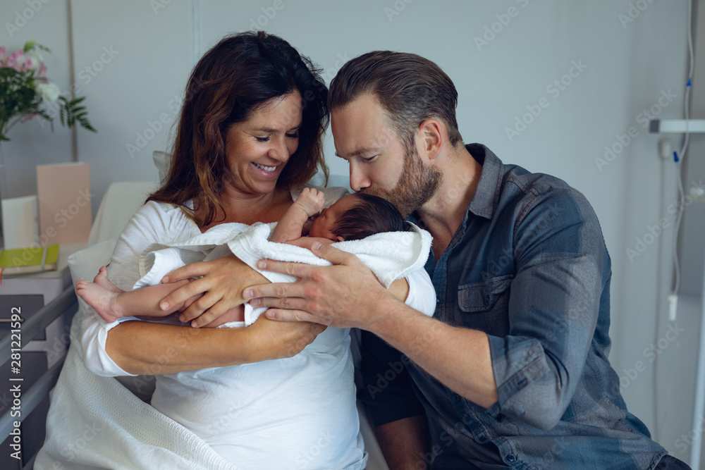 Couple holding their newborn baby in the ward - obrazy, fototapety, plakaty 