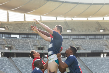 Wall Mural - Male rugby players playing rugby match in stadium