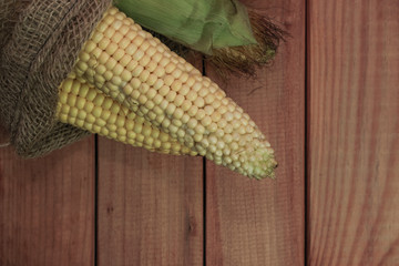 Poster - Fresh Sweet corn in bag on a red   wooden table beautiful background.