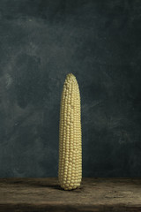 Poster - Fresh Sweet corn on a old oak  wooden table and beautiful grey wall background.