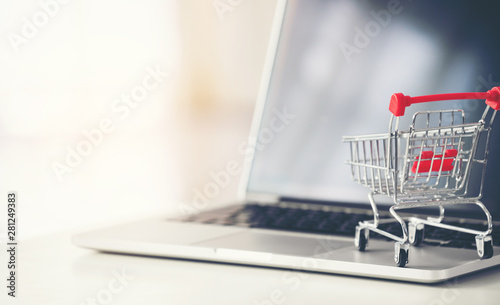 Fotografía shopping cart with laptop on the desk