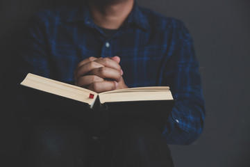 Wall Mural - Man studying the Holy Bible on a wooden table.