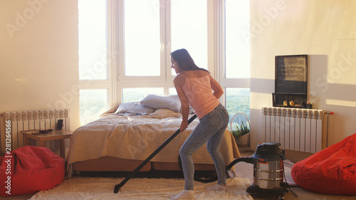 Young Woman Is Hoovering The Floor At Home Using Modern Vacuum