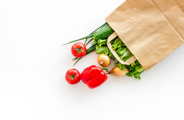 Wall Mural - Healthy food with fresh vegetables in paper bag on white background top view space for text