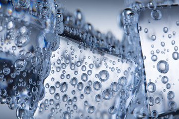 Large ice cubes in the water. Ice cubes and air bubbles in water close up.