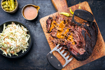 Wall Mural - Traditional barbecue wagyu pulled beef with coleslaw and spicy sauce as top view on a rustic cutting board