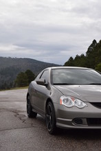 Grey Sports Car On The Road With Mountain Background