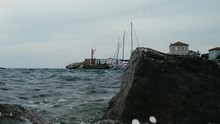 Slow Motion Slider Shot Of Waves Crashing Against The Rocks On The Quayside Of Nerezin Harbour, Croatia.