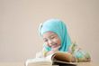 © Asada - Muslim kid reading the book in the class. Education concept
