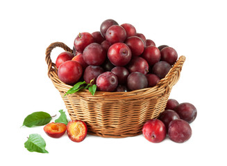 Wall Mural - Ripe red plums with leafs in a basket on a white background.