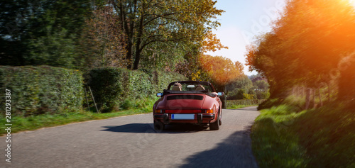 sports car drinving on a road on summer day Canvas Print