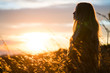 © Westend61 - Side view of woman standing in field during sunset