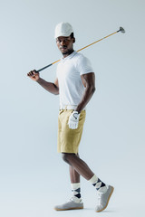 Wall Mural - confident african american golf player looking at camera on grey background