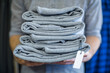 © Westend61 - Man holding stack of folded clothes