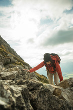 Austria, Tyrol, Tannheimer Tal, Young Woman Climbing On Rocks