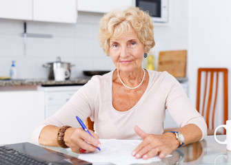 Wall Mural - Mature woman filling up documents