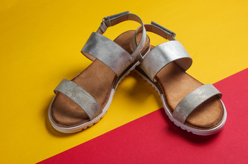 Fashionable female sandals on a yellow red background close-up