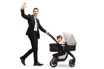 businessman father in a suit pushing a buggy with a baby and waving