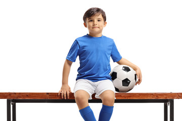 Wall Mural - Boy with football sitting on a bench