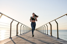 Running Sportswoman On Wooden Pier