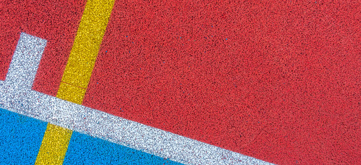 Colorful sports court background. Top view to red and blue field rubber ground with white and yellow lines outdoors