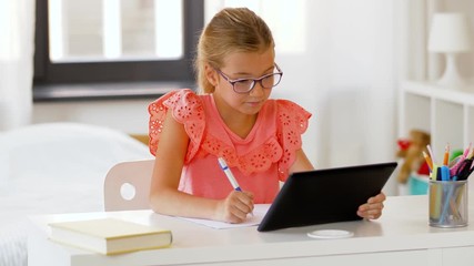 Poster - children, education and learning concept - student girl with tablet computer writing to notebook at home