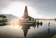 © Akela - from alp to alp/Stocksy - beautiful woman standing in a lake looking at a balinese water temple at sunrise