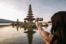 Close Up Of A Woman Taking A Picture With Her Smartphone From A Balinese Water Temple