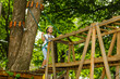 © Angelov - Happy school girl enjoying activity in a climbing adventure park on a summer day