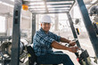 © Raymond Forbes LLC/Stocksy - Portrait of Hispanic man at Work on Forklift