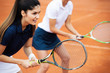 Young happy women friends playing tennis at tennis court