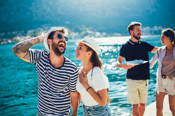 happy group of tourists traveling and sightseeing together near the sea