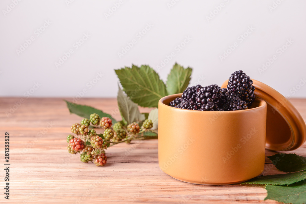 Jar with tasty blackberries on wooden table