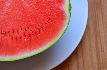 part of  cut watermelon with seeds on the background of the wooden surface