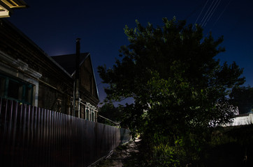 Wall Mural - full moon over quite village at night. beautiful night landscape of old town street with lights. rus