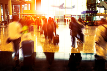 people with traveling luggage walking in airport terminal