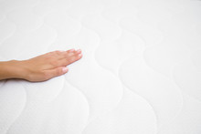 Woman's Hand Touching Cloth Of White Mattress. Checking Softness. Choice Of The Best Type And Quality. Side View. Closeup. Copy Space. Empty Place For Text Or Logo.