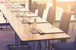 © bigy9950 - Plastic water bottles, Drinking glasses with pencil and white papers setup on the table prepared for seminar or business meeting in the hotel conference room
