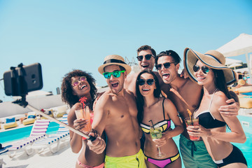 Wall Mural - Six friends hanging out enjoying best company drinking ice cocktails making selfies