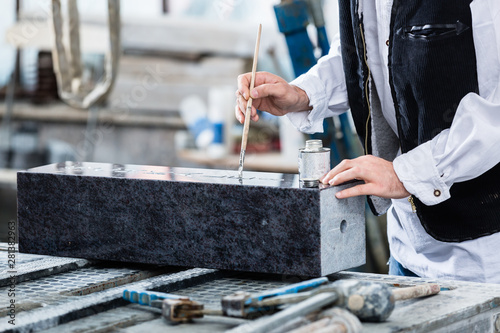 Fotografía Stonemason painting in engraving with silver paint
