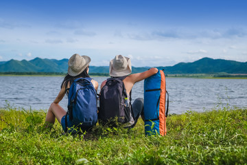 couple traveler standing near the lake background is the mountain and enjoying for beautiful view of nature on holiday.adventure concept.