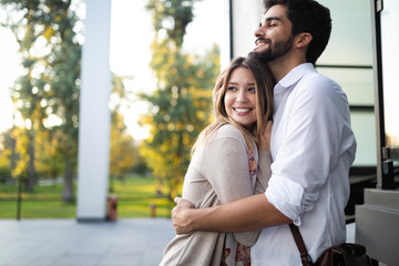 Wall Mural - Happy young couple hugging and laughing outdoors