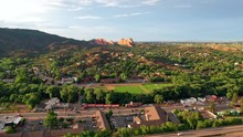 Aerial, Drone Shot, Over Traffc On A Road And Buildings, Towards The Red Mountain Formations, At The Garden Of The Gods Park, On A Sunny Evening, In Colorado Springs, USA