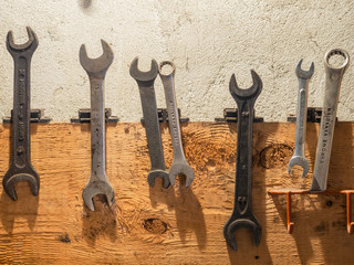 old rusty wrenches on wood wall