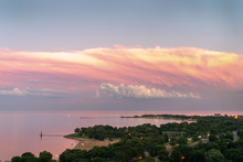 Gorgeous Aerial Sunset View Of Calm Water Of Lake Michigan With Pink Feathery Clouds Layered Over White Fluffy Clouds And Panoramic View Of Montrose And Foster Beach Along Lake Shore Drive In Chicago.