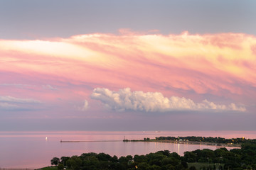 Wall Mural - gorgeous aerial sunset view of calm water of lake michigan with pink feathery clouds layered over wh