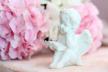 Statuette Of A White Sweet Angel On A Floral Background