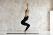 © fizkes - Side view woman doing Chair Pose Utkatasana yoga indoors