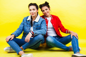 lifestyle people concept: two pretty young school teenage girls having fun happy smiling on yellow background